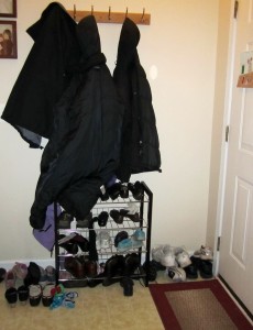 small foyer with a coat and a shoe rack