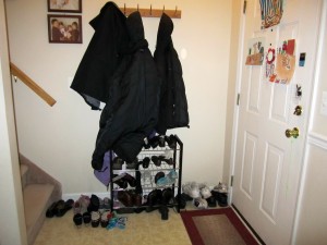 small foyer with a coat rack and a shoe rack