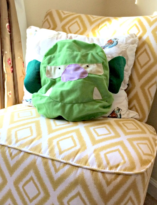 monster pillows on yellow accent chair in living room