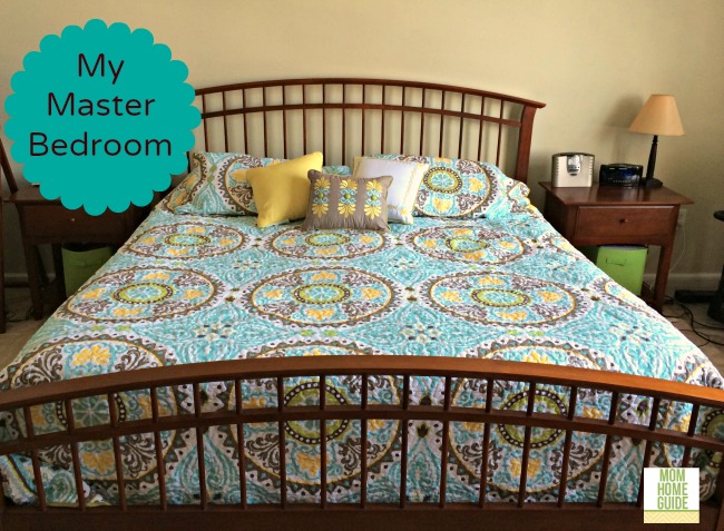 king sized bed with medallion bedspread in blue, green and yellow