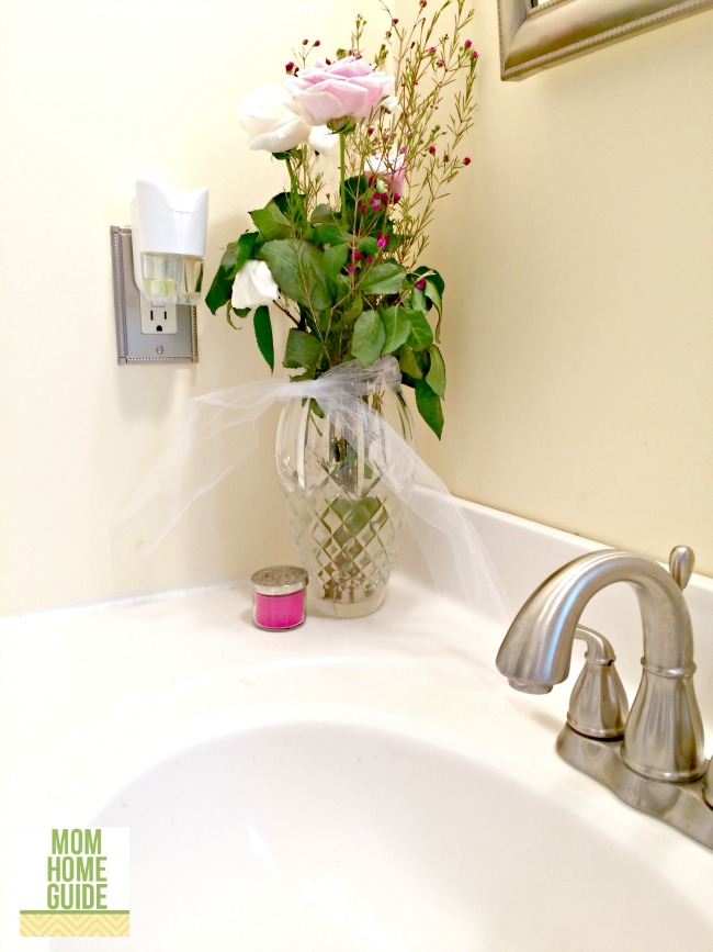 fresh flowers and scented oil in bathroom