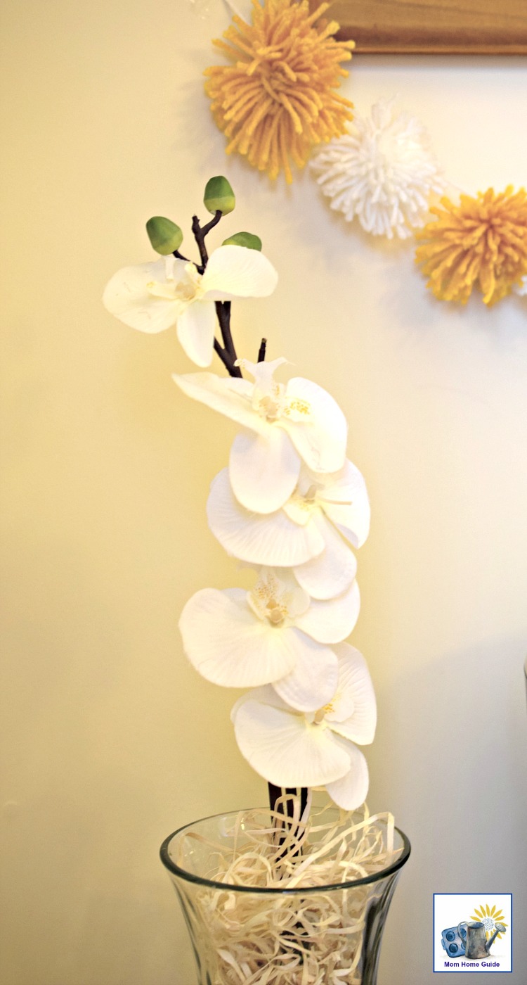 Faux flowers in a vase with aspen wood shavings