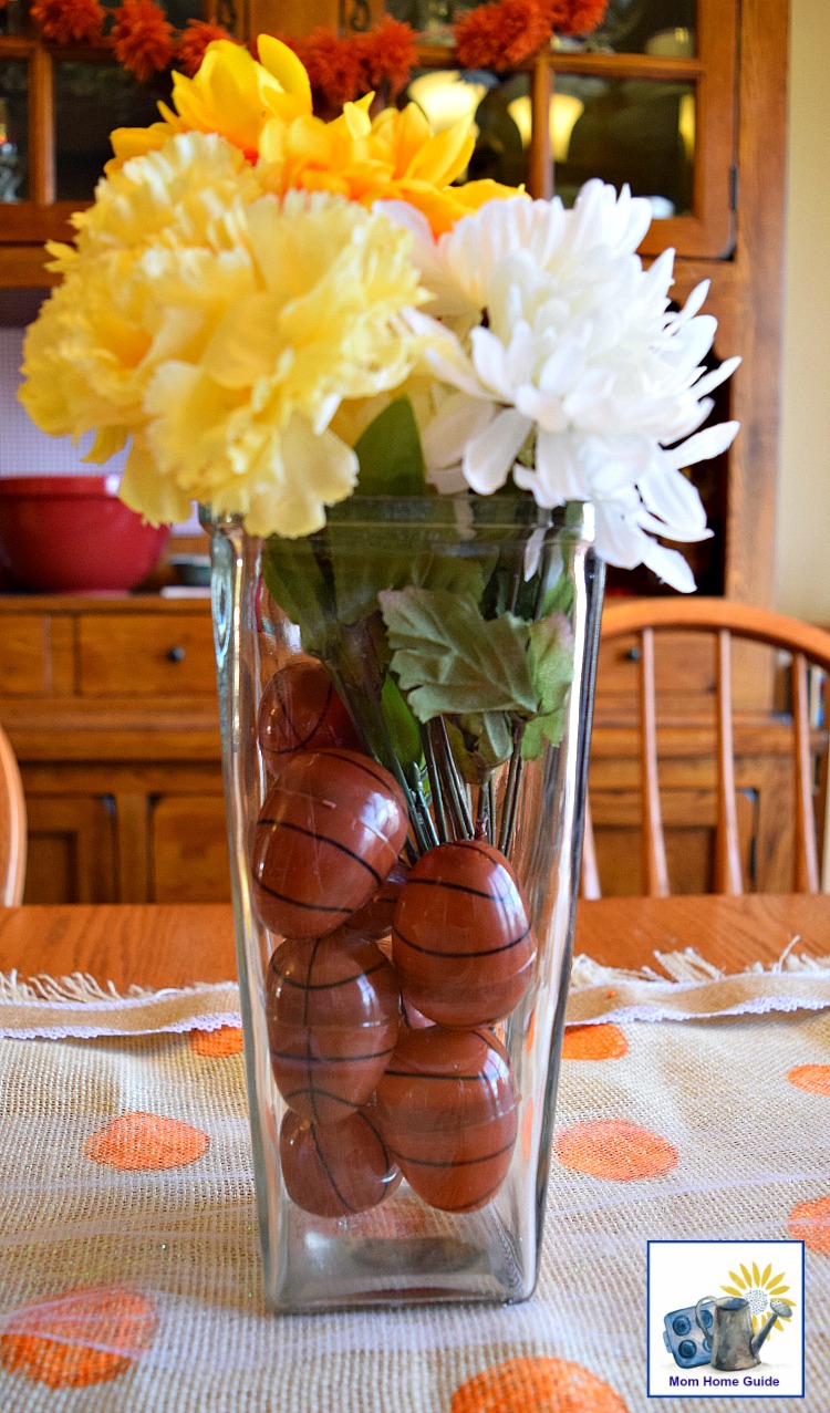 Centerpiece with faux flowers and a basketball filled vase