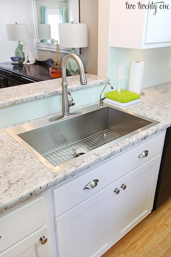 White kitchen with stainless steel accents and gray and white laminate counters