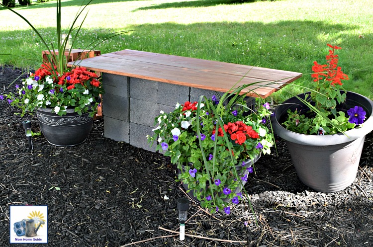 Garden seating area with DIY cinder block and wood bench and container gardens