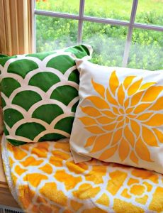Beautiful window seat with a colorful thrown and stenciled pillows