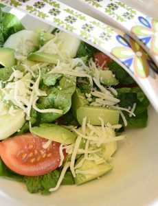 Fresh tomato, spinach and avocado salad with shredded mozzarella cheese