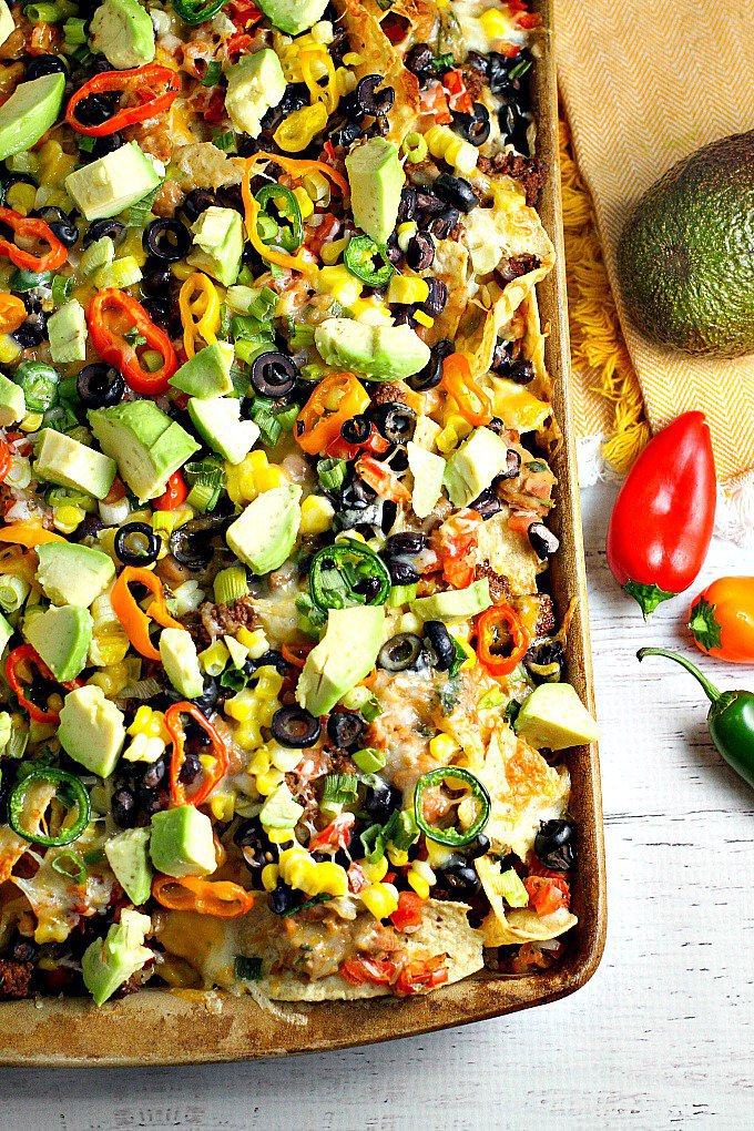 Recipe for loaded nachos with beef, beans, avocado and mini peppers.