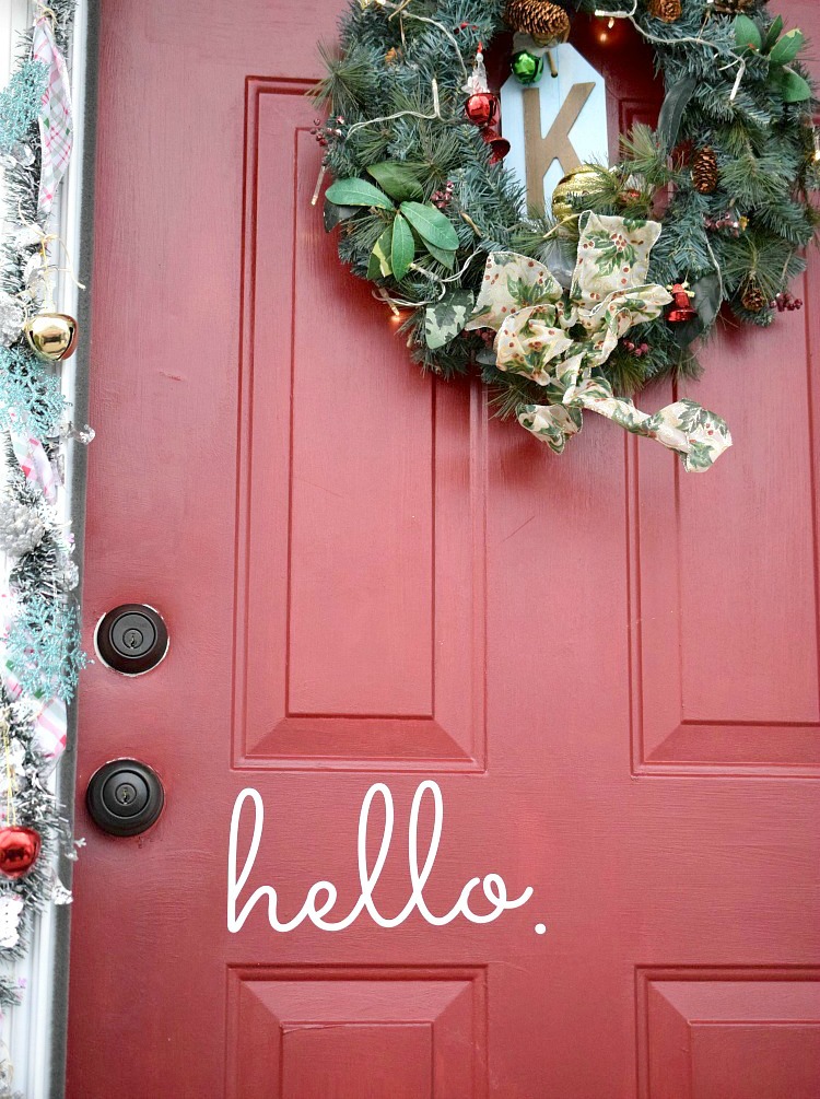 A festive red door decorated for Christmas using Command products.