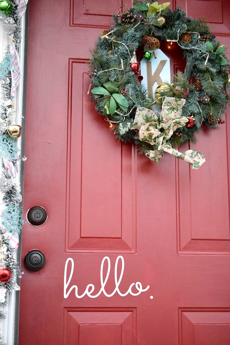 Red front door decorated for Christmas