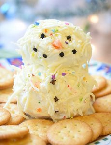 Easy holiday snowman cheese ball recipe with chipotle pepper and pepper jack cheese. Surrounded by Ritz crackers