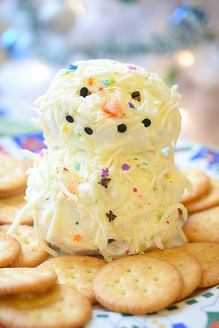 Easy holiday snowman cheese ball recipe with chipotle pepper and pepper jack cheese. Surrounded by Ritz crackers