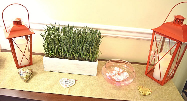 Console table with red lanterns and faux greenery