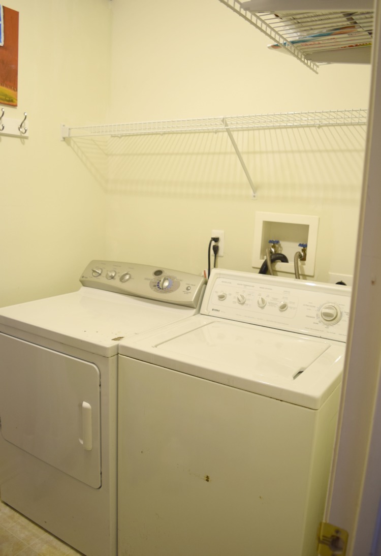 beige laundry room with white washer and dryer
