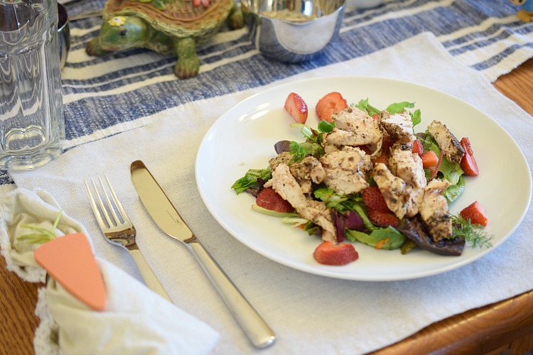 A fresh spring salad with balsamic-vinegar-glazed chicken breasts, a mixed green and herb salad, and fresh strawberries