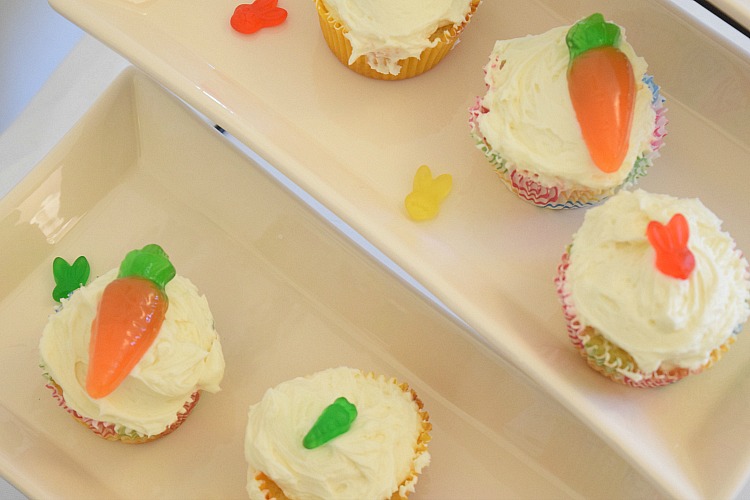 Spring vanilla buttercream cupcakes decorated with gummy carrots and bunnies