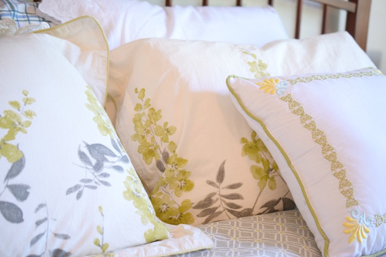 gray and yellow pillows on a king bed