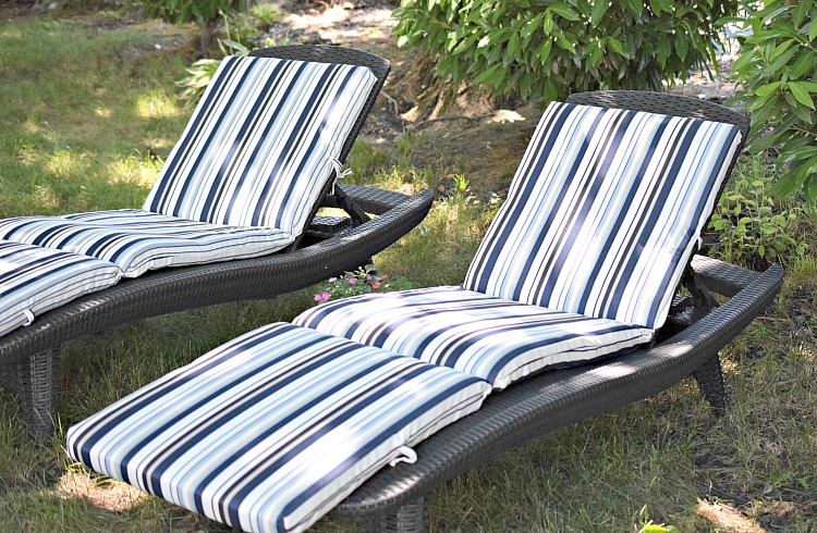 Faux wicker chaise lounges with blue and white striped cushions