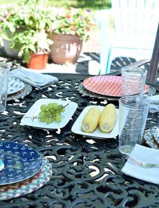 A table set with fun outdoor dinner plates, outdoor placemats, serving pieces and sterling silver dinnerware.