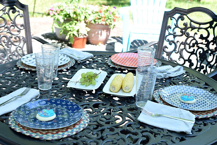 A table set with fun outdoor dinner plates, outdoor placemats, serving pieces and sterling silver dinnerware.