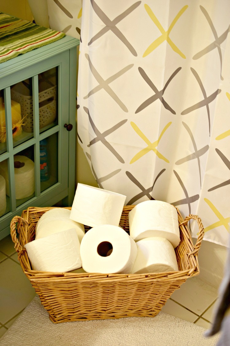 Quilted Northern toilet paper in a basket in a guest bathroom. It's good to stock a basket with extra toilet paper for your guests