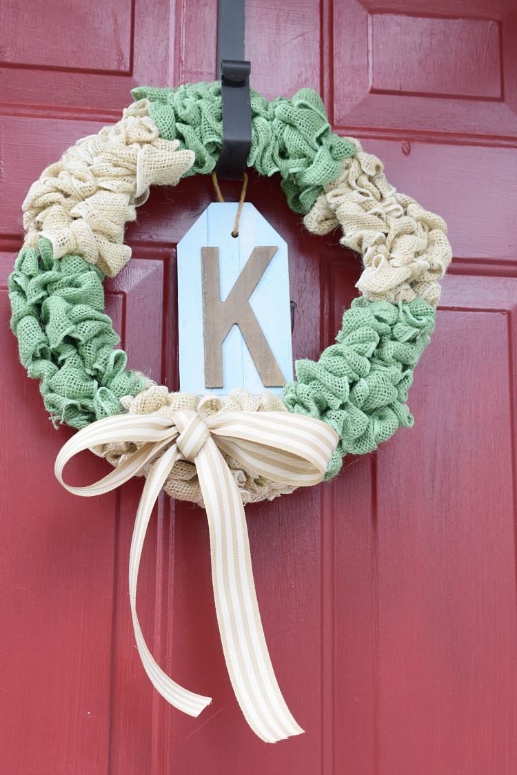 white and green burlap bubble wreath on a red front door