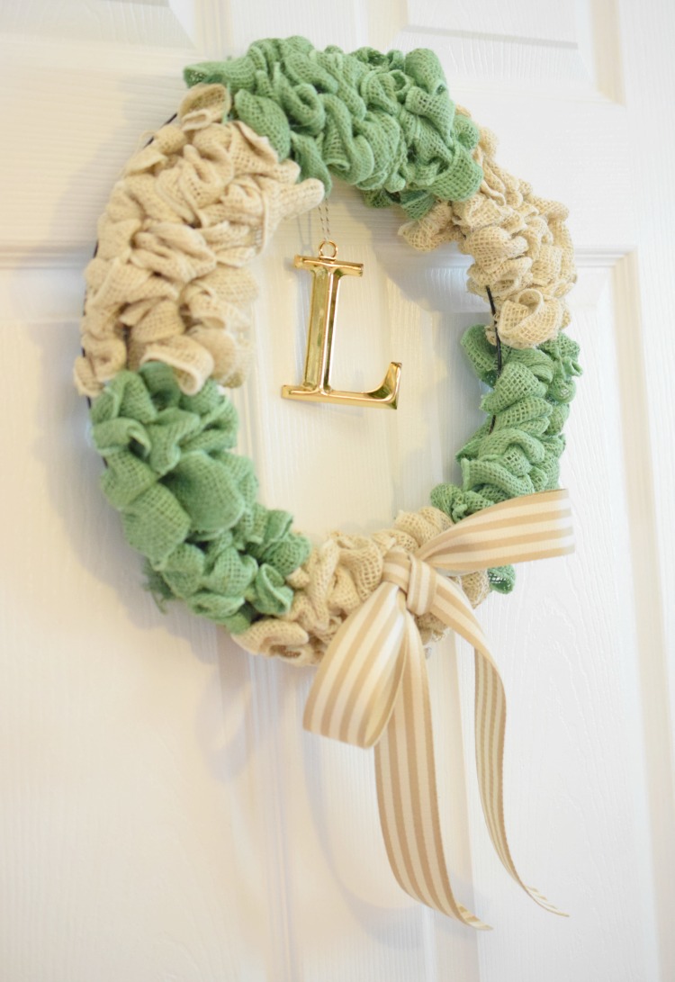 Green and white burlap wreath hung on a white front door