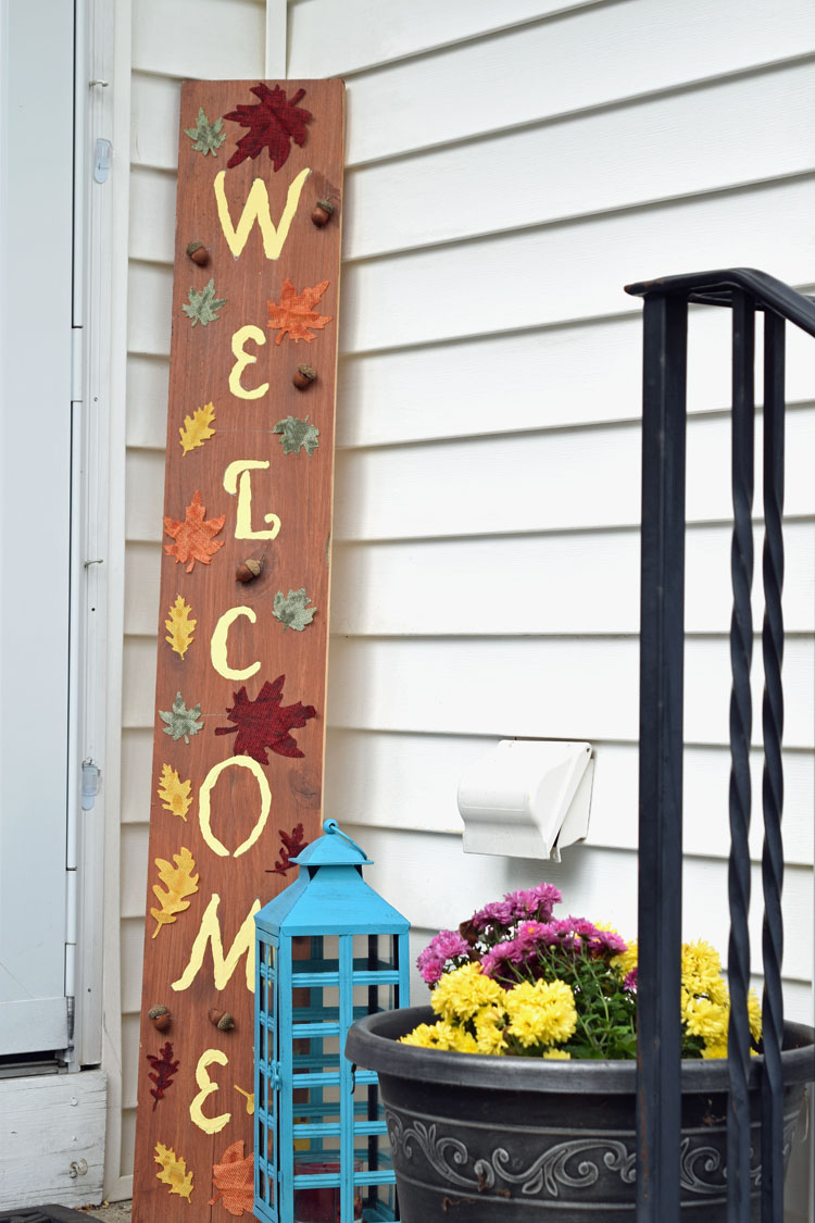 Fall porch welcome sign, lantern and mums on a fall front porch