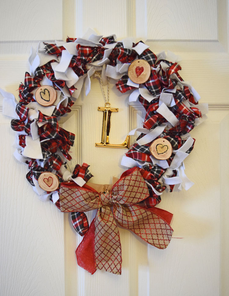 How to make an easy scrappy Valentine's Day wreath from ribbon and felt. The mini log rounds are decorated with drawn-on hearts and glitter paint.