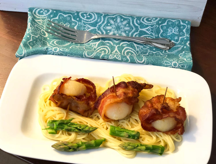 An Easter appetizer -- scallops wrapped in bacon and served with buttery angel hair pasta and fresh asparagus 