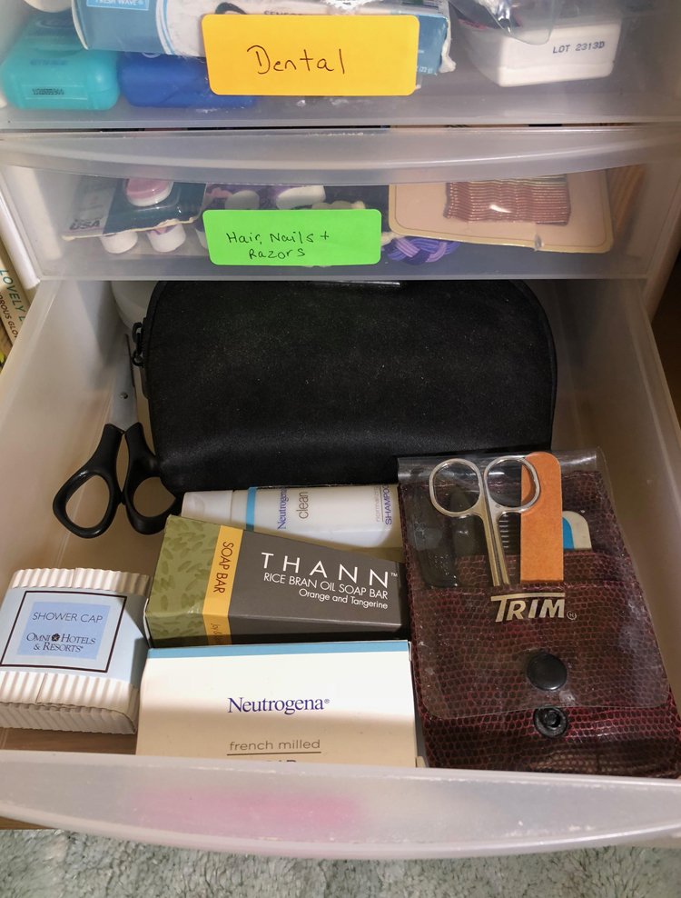 a bathroom drawer organized with mini travel sized items such as shampoo