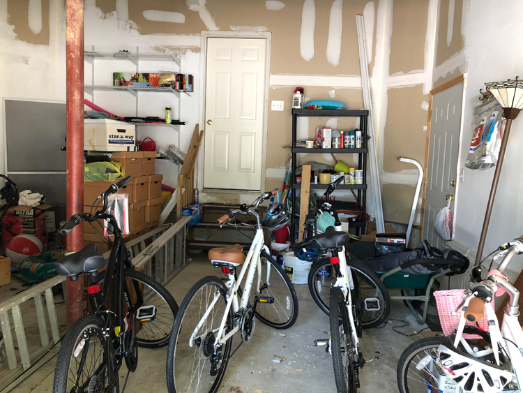 a messy garage with bikes and other odds and ends that could use a good storage system and a makeover