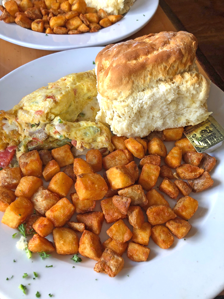 seafood omelette with scallops and shrimp, with breakfast potatoes and biscuit served at Toast restaurant in Charleston