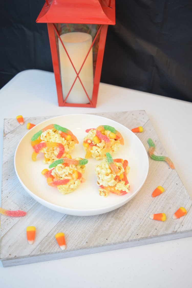 Halloween marshmallow popcorn balls with gummy worms and candy corn