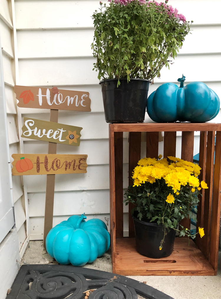 small fall front porch with home sweet home sign, wood crate, mums and lantern