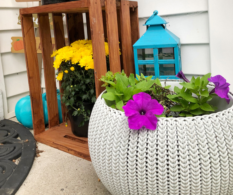tuquoise lantern, walnut stained crate and mums on a fall front porch