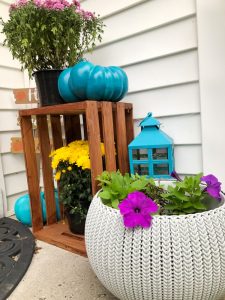 small front porch with turquoise pumpkin, lantern, mums, petunia and wood crate