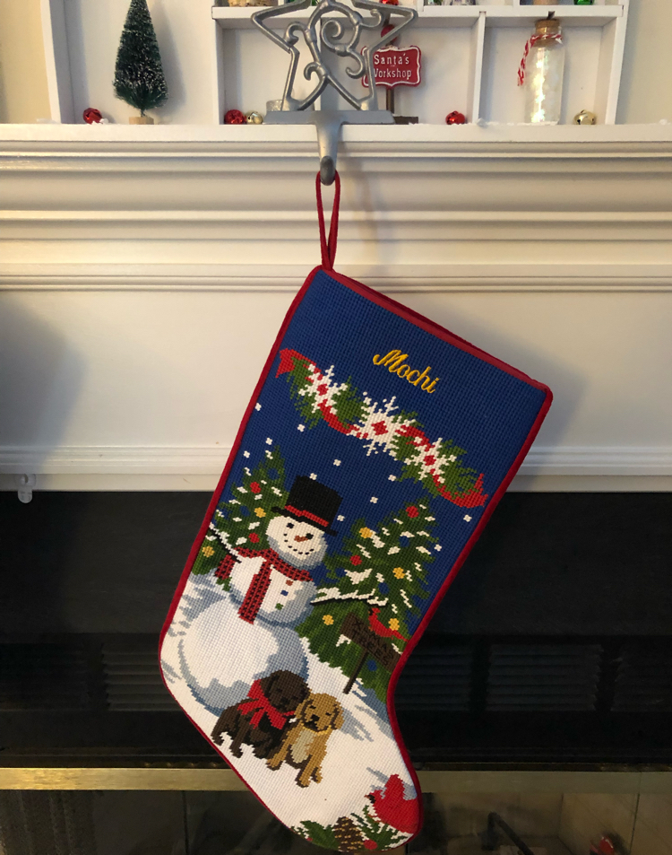 blue needlepoint stocking with two puppies and a snowman
