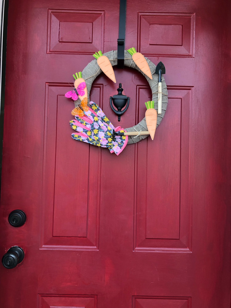 This spring gardening wreath was easy to make with burlap ribbon and inexpensive items from Target and the dollar store