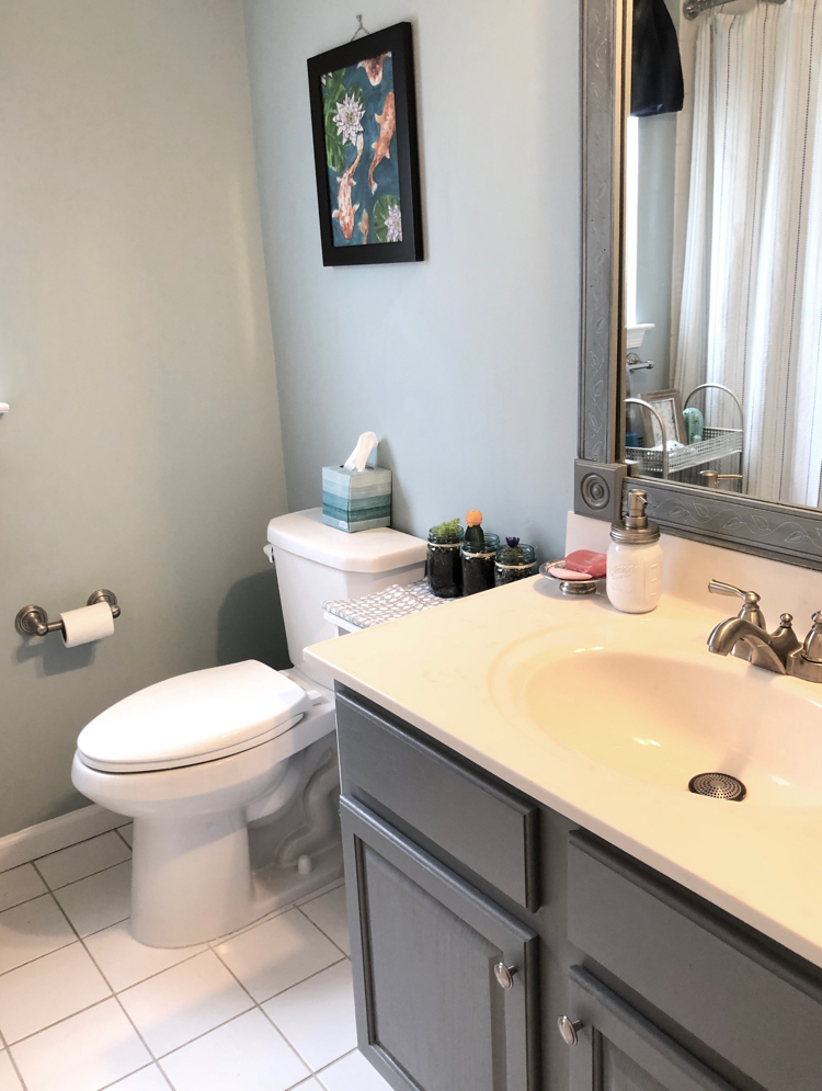 A bathroom updated with blue paint and a gray painted cabinet and vanity for the One Room Challenge