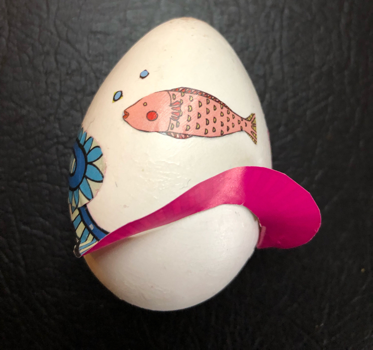 A craft Easter egg decoupaged with fish origami paper