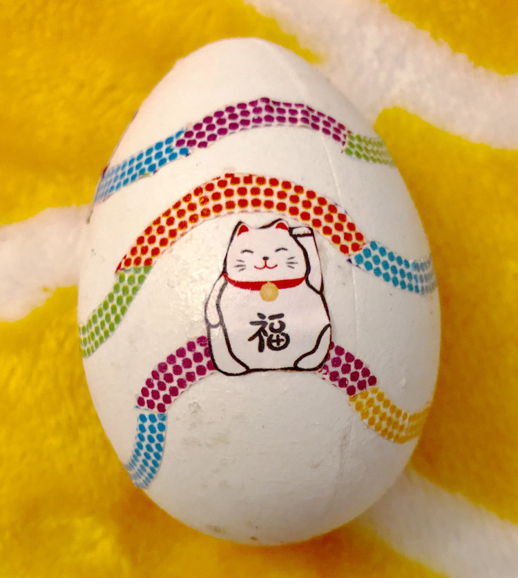 A craft Easter egg decoupaged with maneki-neko origami paper.