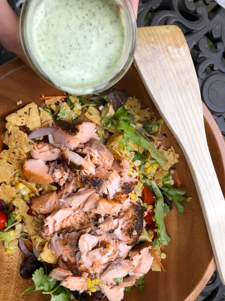 A fresh green salad with Atlantic salmon, avocado, corn and a homemade cilantro lime dressing.