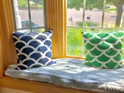DIY window seat cushion in a bay window with colorful pillows