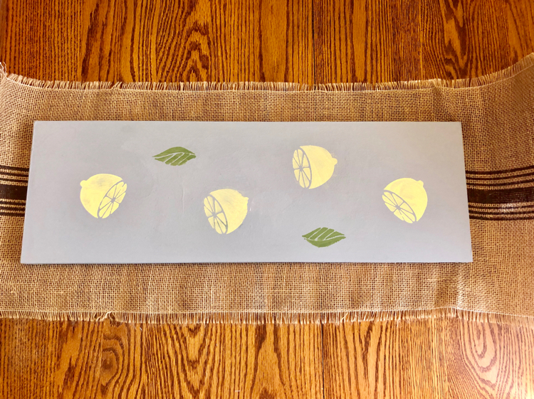 A DIY wooden table runner stenciled with lemons using DecoArt Americana Chalky Finish Paints