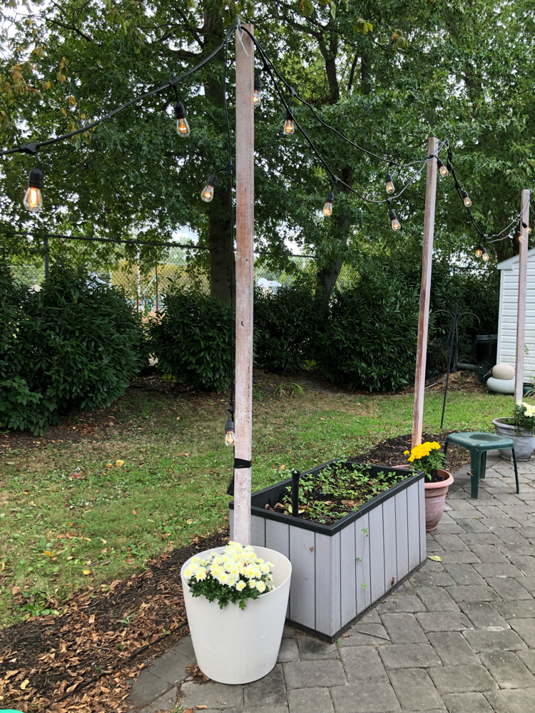 How to hang string lights on a patio from DIY planter string light posts.