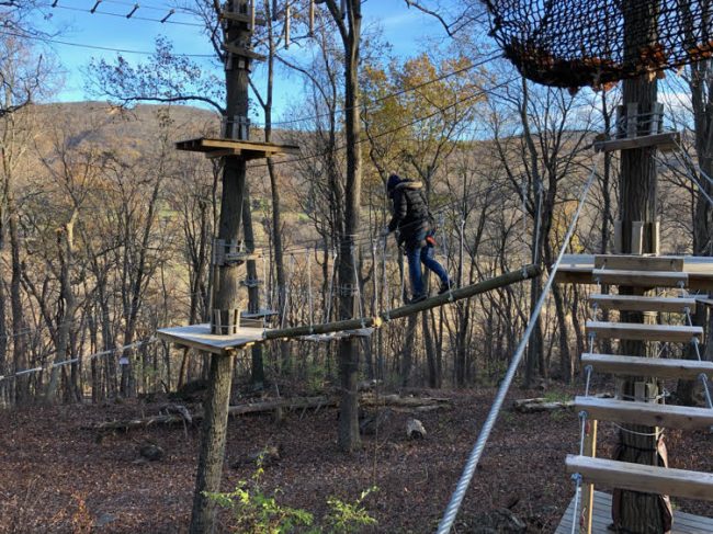 Lauren of Mom Home Guide navigates a lofty obstacle at the TreEscape course at Mountain Creek