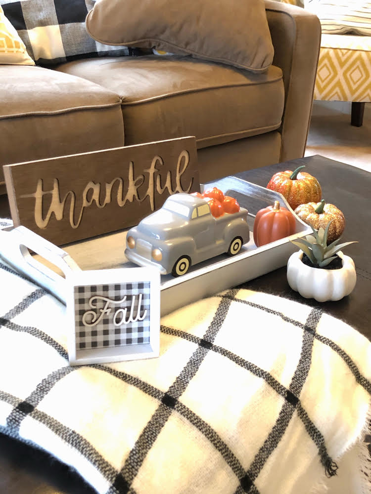 A coffee table decorated for Thanksgiving with "dollar" items from Target and a gray wooden tray from Oriental Trading.