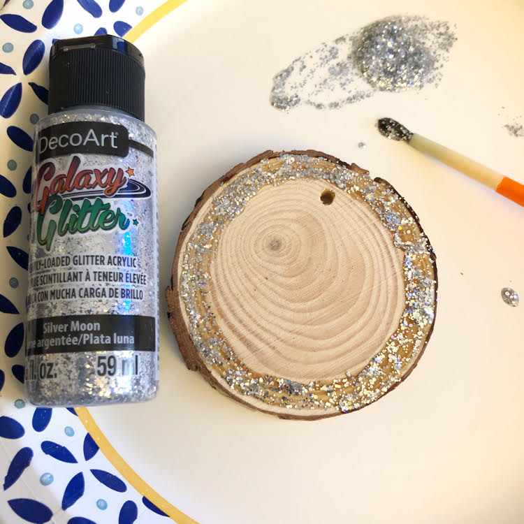 A wood slice painted with Galaxy Glitter in moon-silver by DecoArt