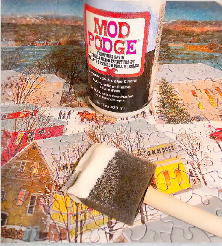 how to glue a jigsaw puzzle together with Mod Podge and a foam craft brush. Shown is a jigsaw puzzle of Stowe, Vermont